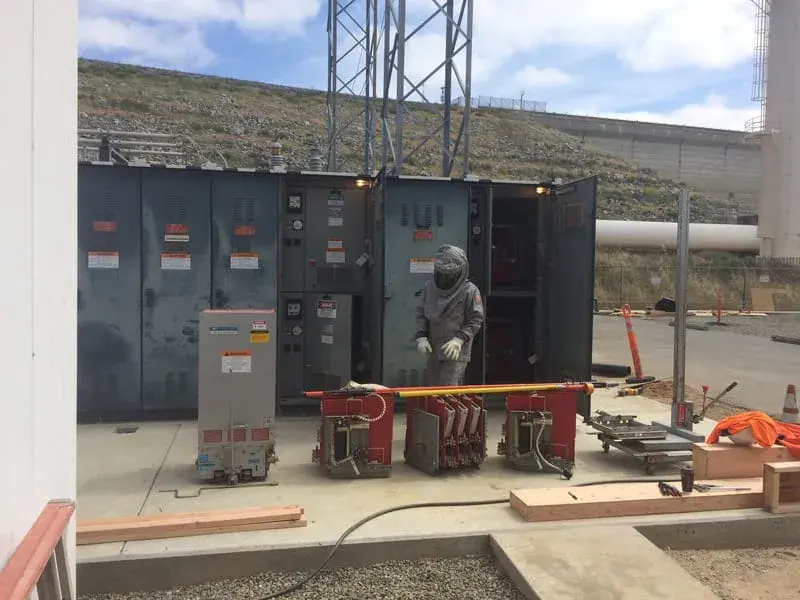 A row of tall grey metal-clad switchgear cubicles standing on a concrete pad ready to be installed