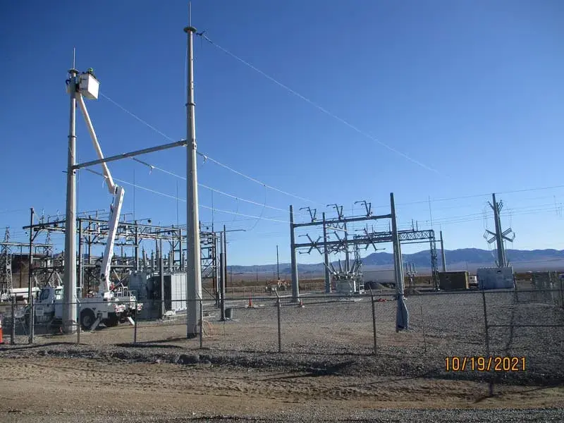 Galvanised steel structures and equipment in a desert substation with mountains on the horizon