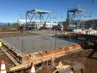 A freshly poured concrete slab within timber formwork on a mountaintop construction site