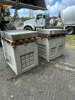 Two precast concrete bases on a truck bed, ready to be set at the airfield