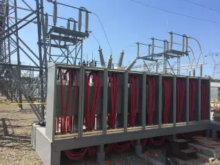 Rows of large red insulated cables terminated in an open switchgear enclosure