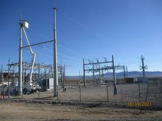 Galvanised steel structures and equipment in a desert substation with mountains on the horizon