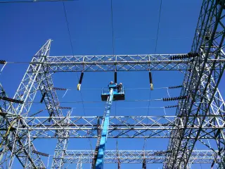 Disconnect switches mounted along a steel substation structure with insulator strings hanging below