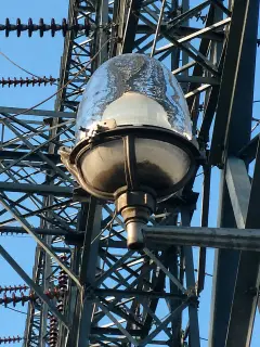 A wrapped electrical bushing suspended on a line inside the steelwork of a switchyard