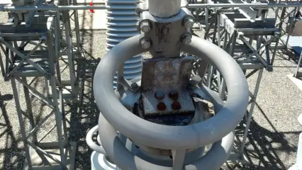Close view of a bolted switch connection above a large aluminium corona ring