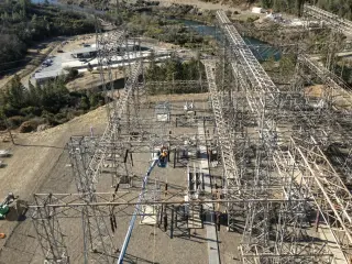 An elevated view across a large switchyard showing rows of structures, bus work and equipment